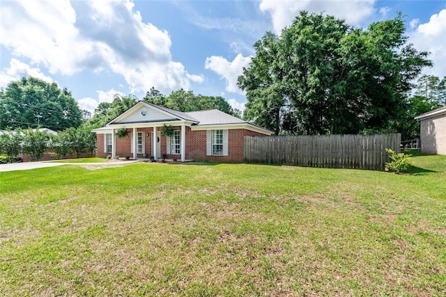 neoclassical home featuring brick siding, a front lawn, fence, and a porch