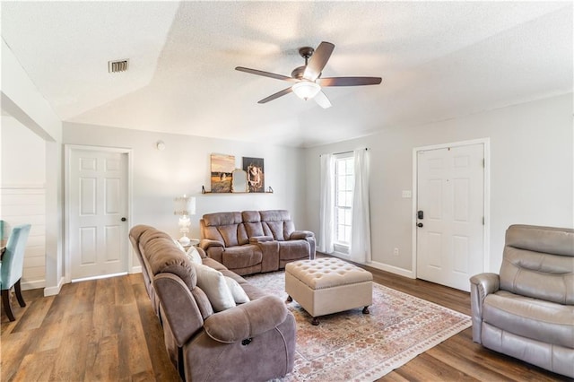 living room with a ceiling fan, a textured ceiling, visible vents, wood finished floors, and baseboards