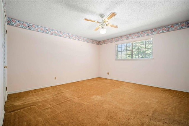 empty room with a textured ceiling, carpet flooring, and ceiling fan