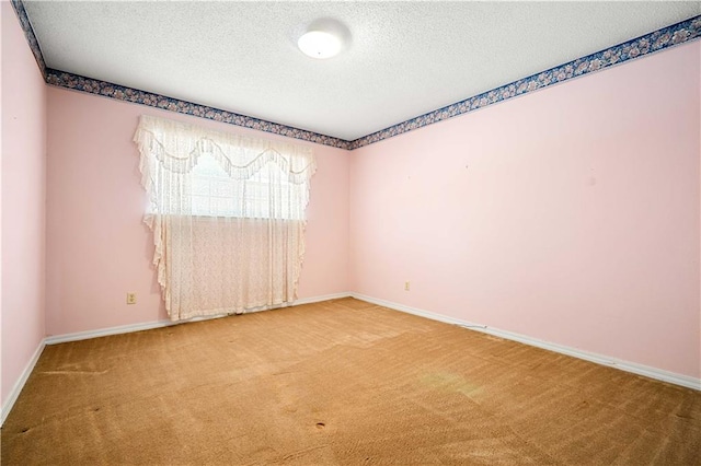 carpeted empty room featuring a textured ceiling