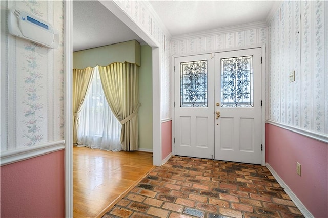 entrance foyer featuring a wealth of natural light, ornamental molding, and french doors