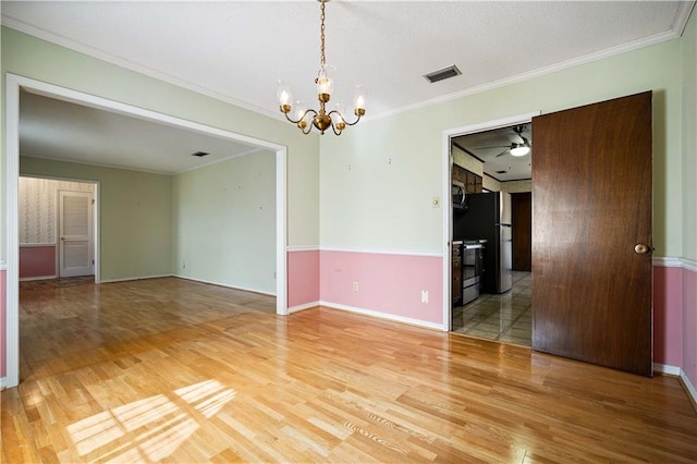 empty room featuring hardwood / wood-style floors, crown molding, and ceiling fan with notable chandelier