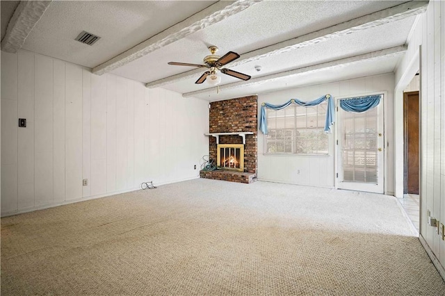 unfurnished living room with beam ceiling, carpet flooring, a textured ceiling, and a fireplace