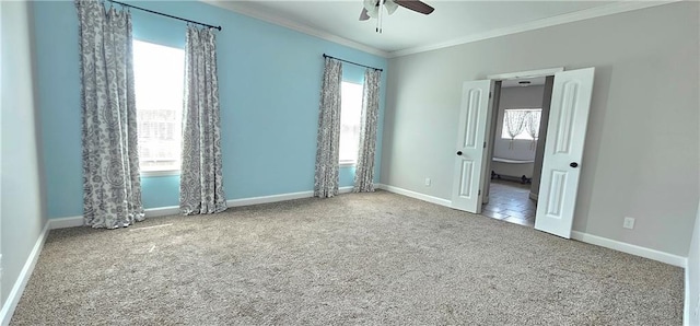 carpeted spare room featuring ceiling fan and ornamental molding