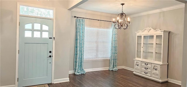 foyer entrance with plenty of natural light, dark hardwood / wood-style flooring, ornamental molding, and an inviting chandelier