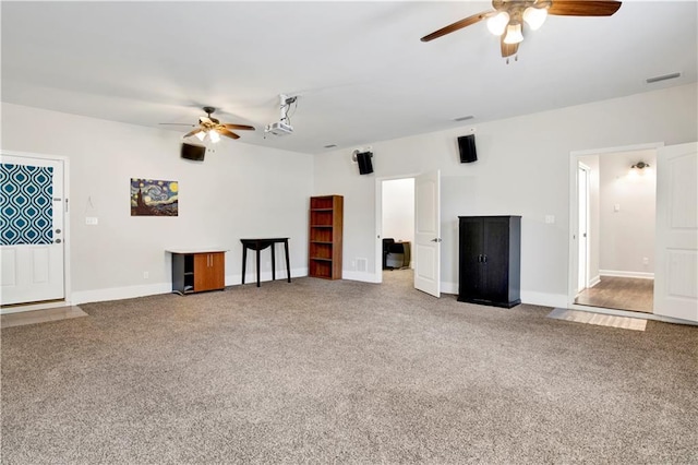 unfurnished living room featuring ceiling fan and carpet