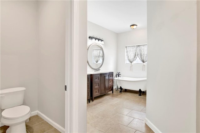 bathroom featuring toilet, vanity, and a washtub