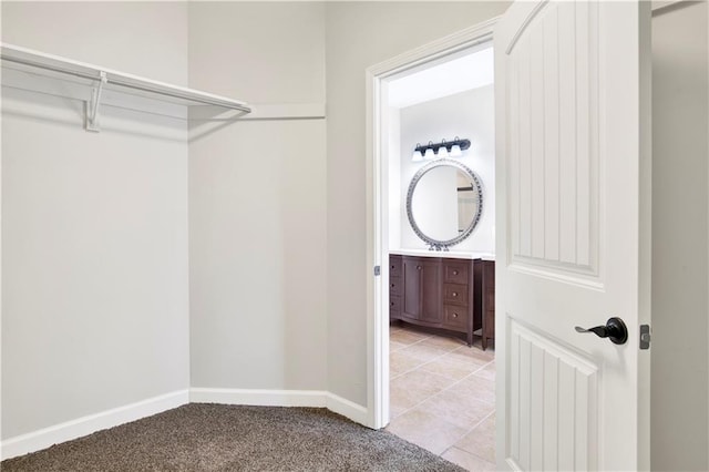 walk in closet with light colored carpet