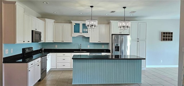 kitchen featuring white cabinets, pendant lighting, stainless steel appliances, and a center island