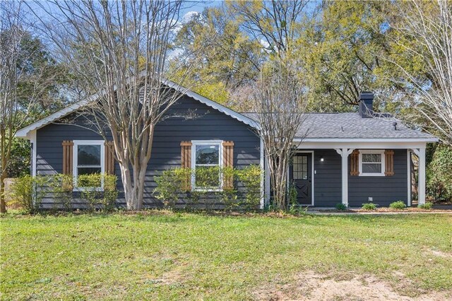 single story home featuring a chimney and a front yard