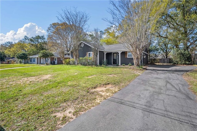 ranch-style house featuring a front lawn and aphalt driveway