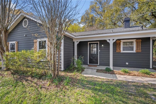 doorway to property with a porch and a chimney