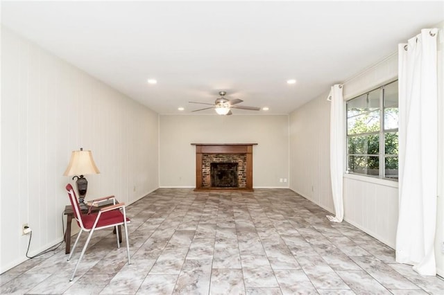 unfurnished living room with ceiling fan and a brick fireplace