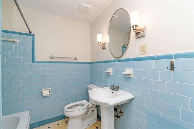 bathroom with shower / washtub combination, tile patterned flooring, tile walls, and toilet