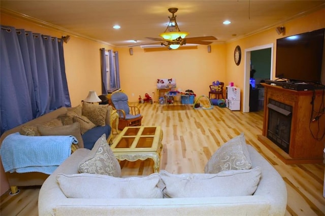 living room featuring ceiling fan, light hardwood / wood-style floors, and ornamental molding