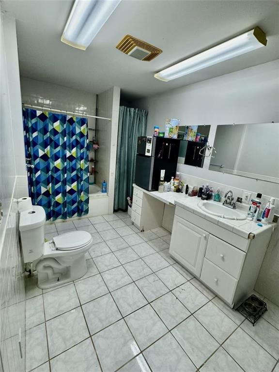 full bathroom with tile patterned floors, vanity, toilet, and shower / tub combo