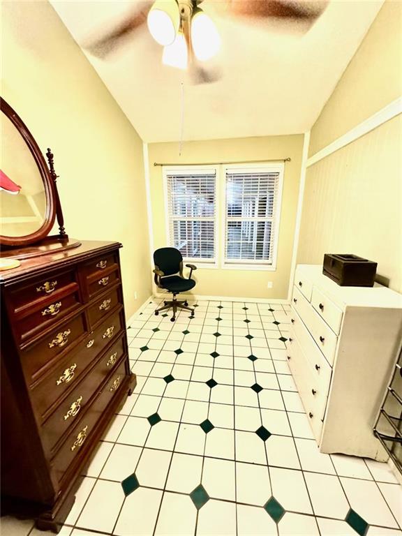 sitting room with light tile patterned floors and vaulted ceiling