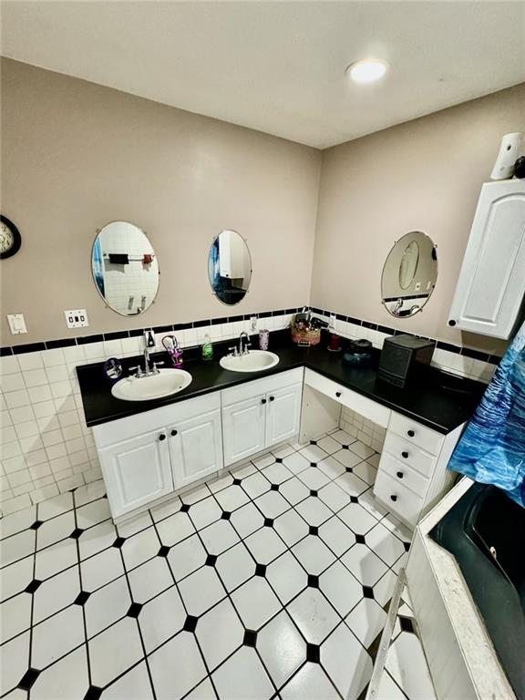 bathroom with vanity and tile walls