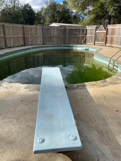 view of pool with a diving board