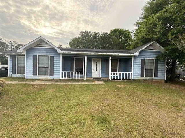 ranch-style home featuring a porch and a front lawn