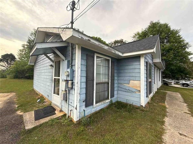view of side of home featuring roof with shingles