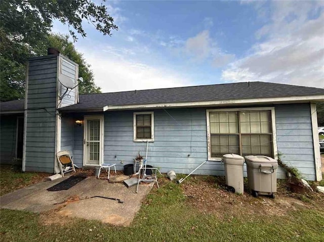 rear view of house featuring a chimney and a patio