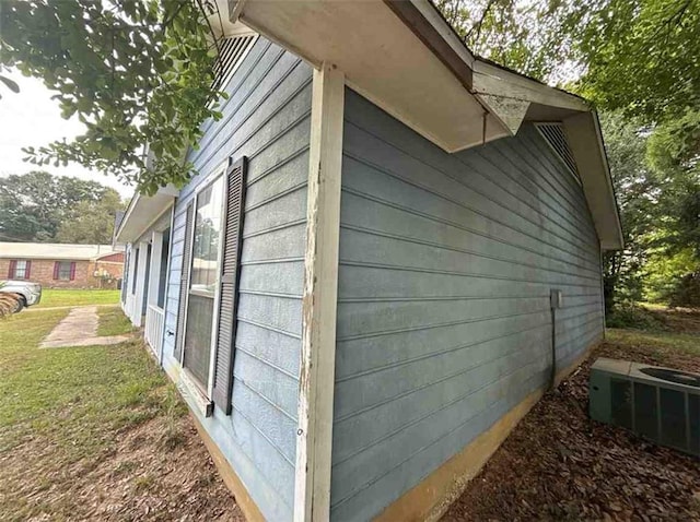 view of home's exterior featuring central air condition unit and a yard