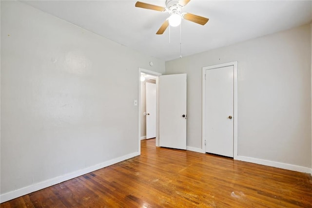 unfurnished bedroom with ceiling fan, baseboards, and wood finished floors