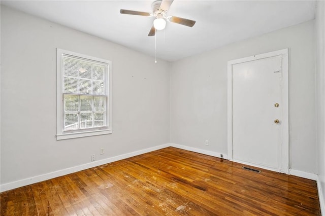 unfurnished room featuring ceiling fan, wood-type flooring, visible vents, and baseboards