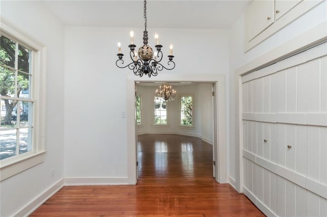 interior space with hardwood / wood-style flooring, plenty of natural light, and a chandelier