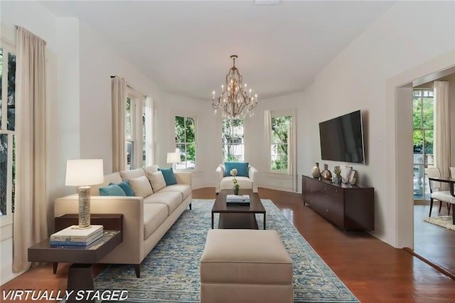 living room featuring dark hardwood / wood-style flooring, a notable chandelier, and a healthy amount of sunlight