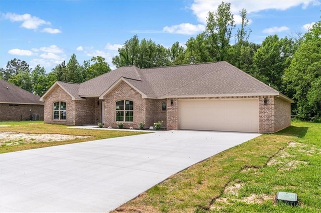 view of front of property featuring a garage, central AC unit, and a front yard