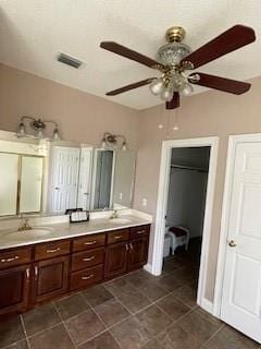 bathroom featuring a sink, visible vents, ceiling fan, and double vanity