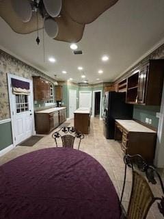 dining space with recessed lighting, a wainscoted wall, crown molding, and wallpapered walls