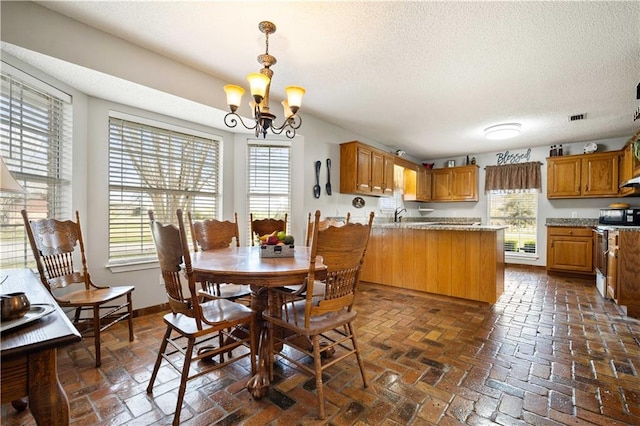 dining area featuring an inviting chandelier, baseboards, brick floor, and a wealth of natural light