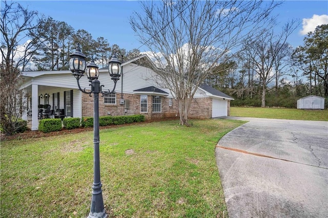 view of front of house with a storage unit, a front lawn, brick siding, and driveway