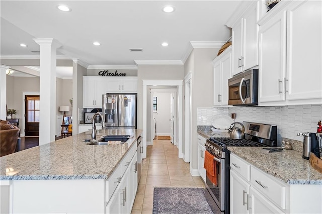 kitchen with crown molding, light tile patterned floors, appliances with stainless steel finishes, a sink, and ornate columns