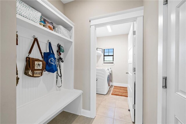 mudroom featuring washer and dryer, baseboards, and light tile patterned floors