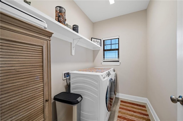 clothes washing area featuring laundry area, washing machine and clothes dryer, and baseboards