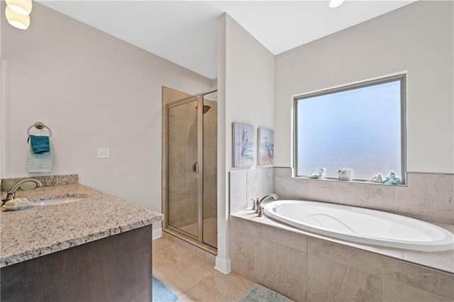 bathroom with a stall shower, vanity, a garden tub, and tile patterned floors