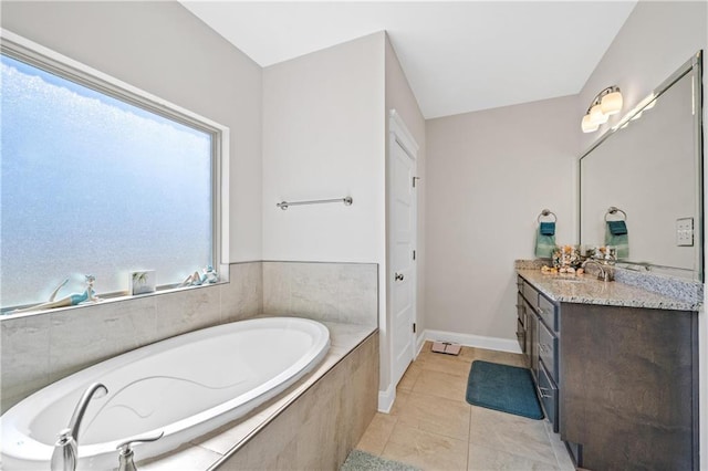 full bath featuring tile patterned flooring, baseboards, a bath, and vanity