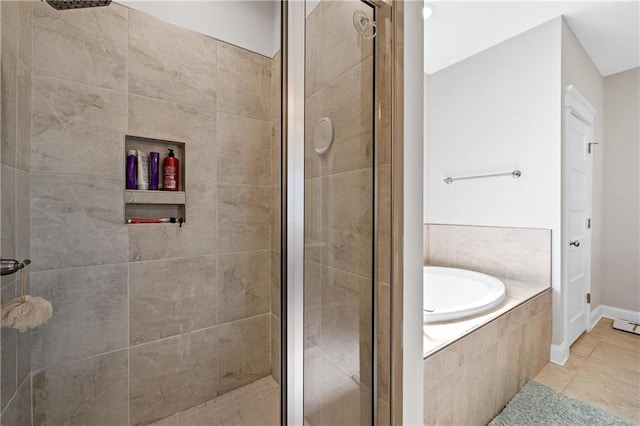 bathroom with a garden tub, a shower stall, and tile patterned floors