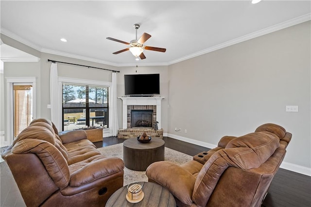 living room with dark wood-type flooring, a fireplace, crown molding, and baseboards