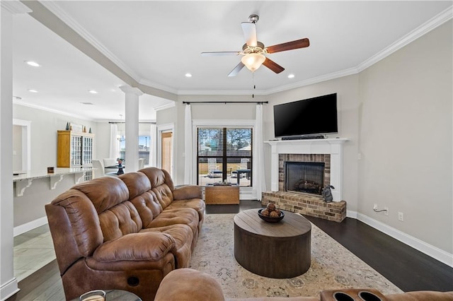 living area featuring a brick fireplace, crown molding, and baseboards