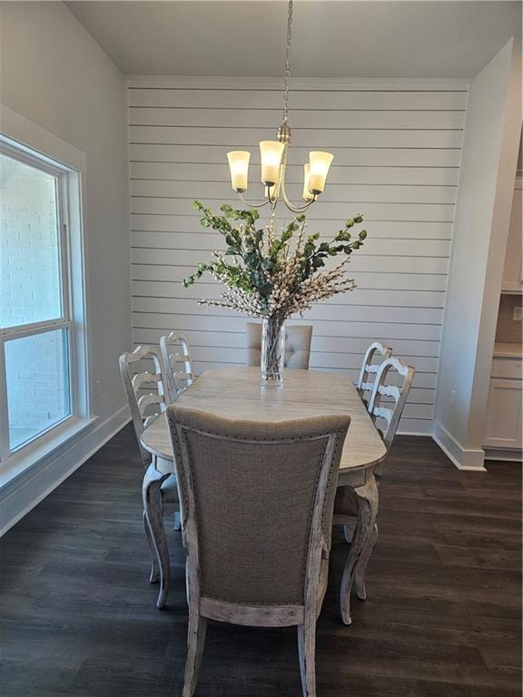 dining area with dark hardwood / wood-style flooring and a chandelier