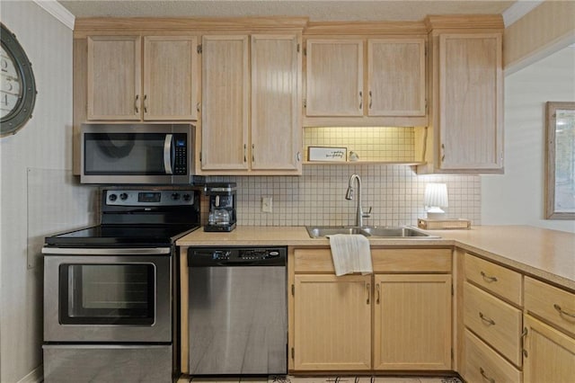kitchen with stainless steel appliances, light brown cabinets, a sink, light countertops, and backsplash