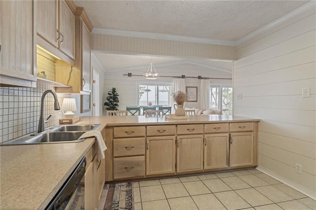 kitchen featuring a sink, a peninsula, ornamental molding, light countertops, and light brown cabinetry