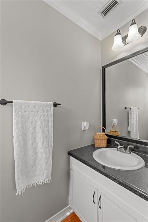 bathroom featuring ornamental molding, vanity, and wood finished floors