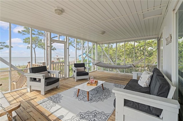 sunroom featuring a water view