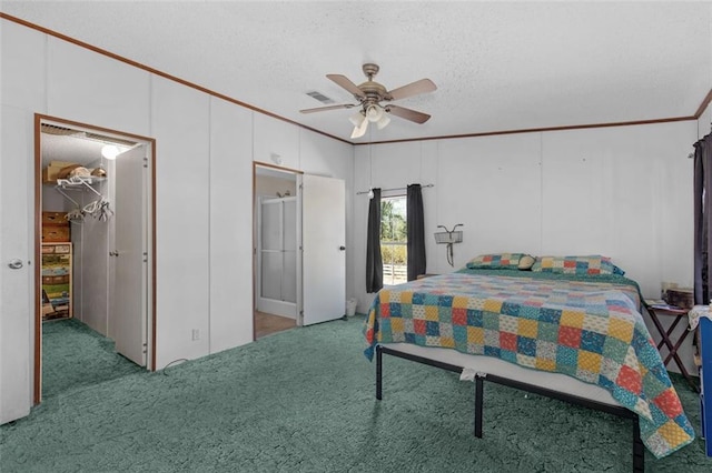 bedroom with light carpet, a textured ceiling, a walk in closet, and crown molding